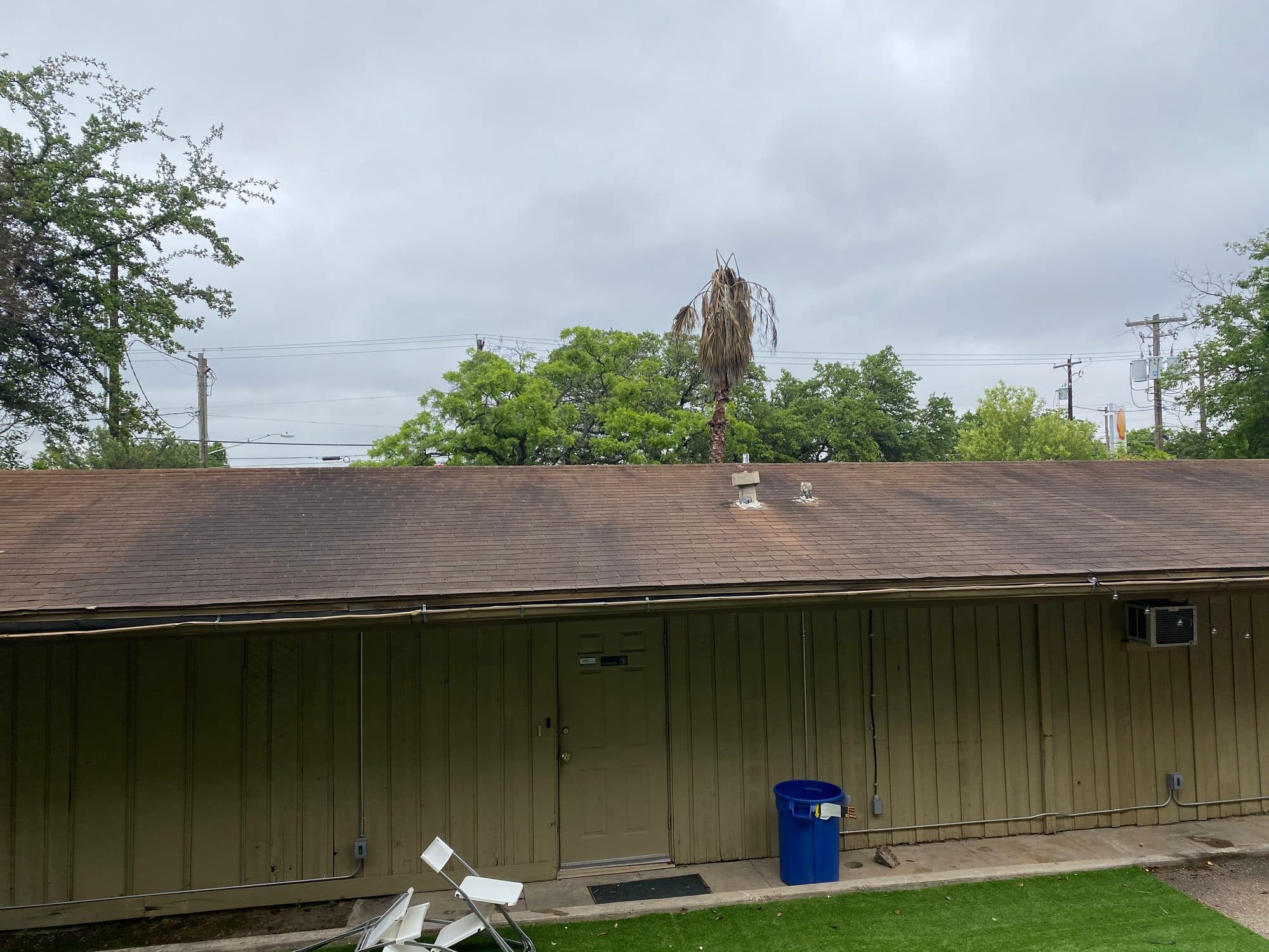 Building exterior before roof and siding wash with dark staining on roof